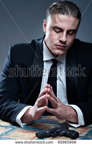stock-photo-frustrated-young-man-in-suit-preparing-for-suicide-black-gun-on-table-60965998.jpg
